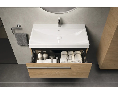 Wastafelmeubel met open lade, handdoeken en toiletartikelen