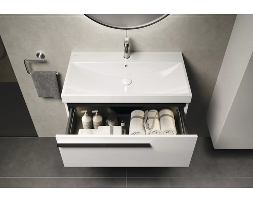 Wastafelonderkast met open lade, wastafel, handdoek en handdoekhouder in een badkamer