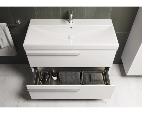 Witte wastafel met open lade met houders en handdoeken, voor badkamerontwerp.