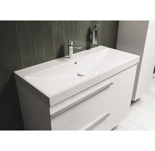 Witte wastafel met twee laden, kraan en zeepdispenser