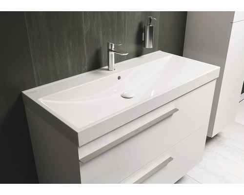 Witte wastafel met twee laden, kraan en zeepdispenser