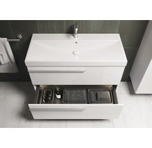 Witte wastafel met open lade met badkamerartikelen en manden