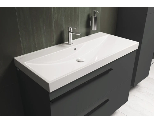 Wastafelmeubel met kraan en zeepdispenser in de badkamer.