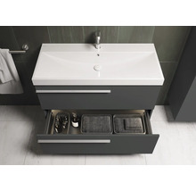 Wastafelmeubel met open lade waarin badkamerbenodigdheden en manden staan