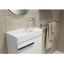 Wastafel met kraan, handdoek en spiegel in de badkamer