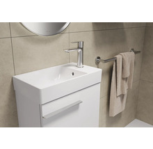 Badkamer wastafelmeubel met kraan, handdoekhouder en handdoek.