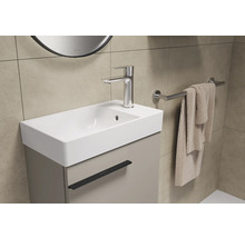 Badkamer wastafel met onderkast, kraan en handdoekhouder.