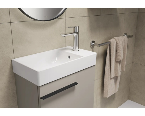 Badkamer wastafel met onderkast, kraan en handdoekhouder.