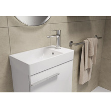 Lichte badkamer met wastafelonderkast, kraan en handdoekrek