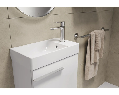 Lichte badkamer met wastafelonderkast, kraan en handdoekrek