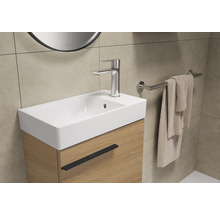 Wastafel met kraan en handdoekhouder in de badkamer