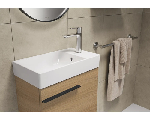 Wastafel met kraan en handdoekhouder in de badkamer