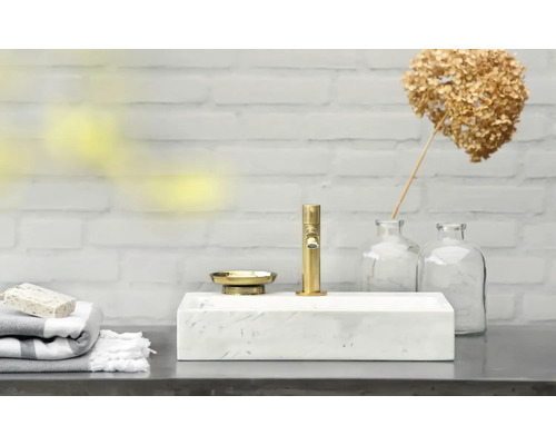 Moderne badkamer met marmeren wastafel, gouden kraan en zeepbakje
