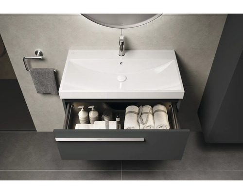 Wastafel met open lade, met handdoeken en verzorgingsproducten erin