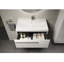 Wastafel met open lade, handdoeken en verzorgingsproducten in moderne badkamer