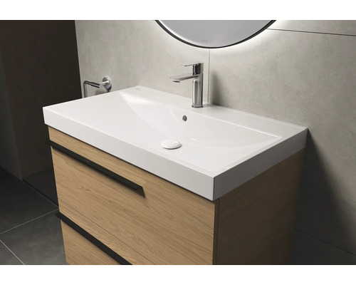 Wastafelmeubel met wastafel en kraan in de badkamer.