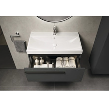 Wastafelonderkast met open lade, wastafel, handdoeken en verzorgingsproducten in de badkamer