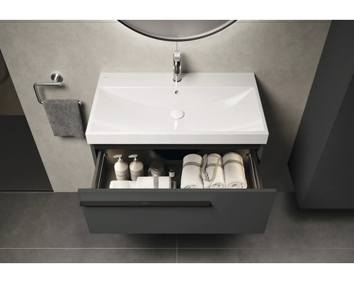 Wastafelonderkast met open lade, wastafel, handdoeken en verzorgingsproducten in de badkamer