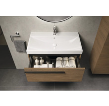 Wastafelonderkast met open lade, wastafel, handdoeken en verzorgingsproducten in een moderne badkamer