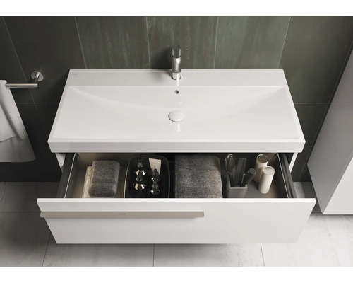 Witte wastafel met open lade in badkamer.