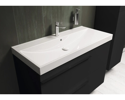 Wastafel met kraan en zeepdispenser in de badkamer