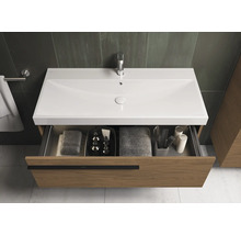 Wastafelonderkast met open lade, voorzien van handdoeken en badkamerartikelen.