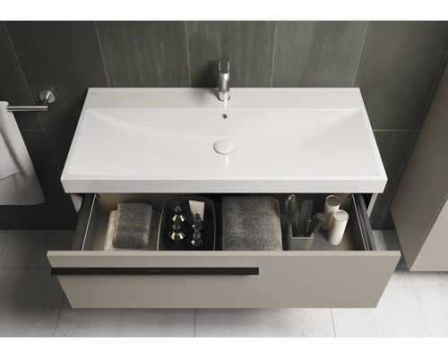 Wastafelonderkast met open lade en diverse badkamerartikelen