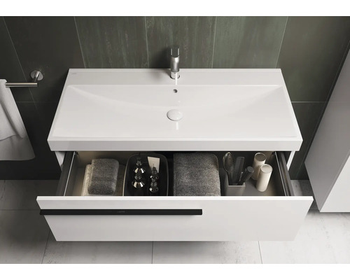 Wastafel met open lade, handdoeken en cosmetica in de badkamer