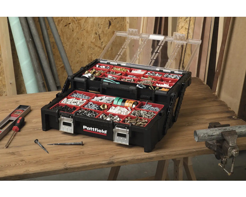 Geopende, zwarte Pattfield gereedschapskoffer met transparant deksel en diverse schroeven, spijkers en pluggen op een houten tafel.