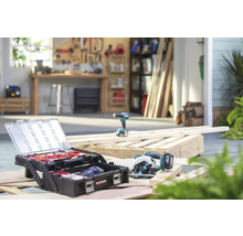 Werkplaatsopname met gereedschapskist, cirkelzaag en boormachine op houten balken