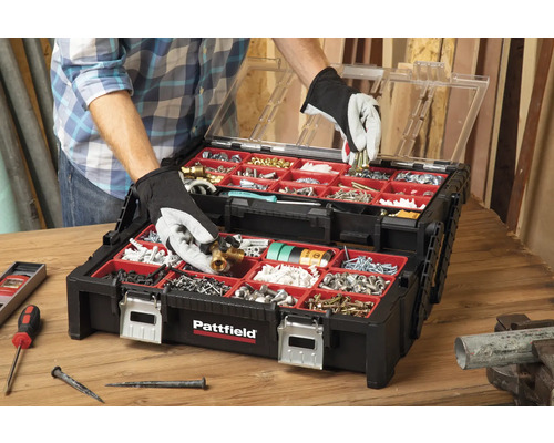 Open zwarte gereedschapskist met rode binnenkant, gevuld met diverse gereedschappen en schroeven.