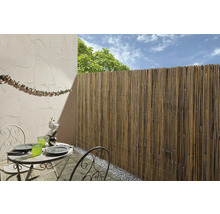 Buitenruimte met bamboehek, tafel en stoelen