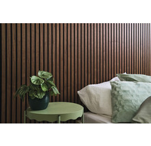 Decoratieve slaapkamer met houten wandpanelen, bed en klein tafeltje met plant