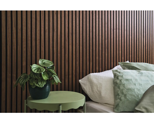 Decoratieve slaapkamer met houten wandpanelen, bed en klein tafeltje met plant