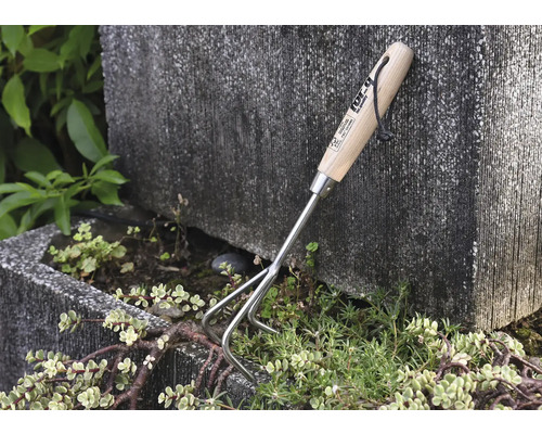 Tuingereedschap met houten handvat en drie tanden om de grond los te maken