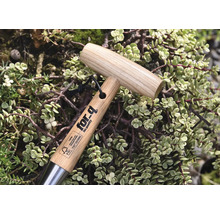 Tuingereedschap met houten handvat en for-q logo, omgeven door planten