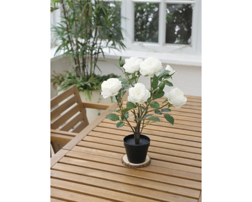 Decoratieve kunstmatige roos in pot op een houten tafel