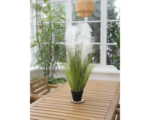 Decoratieve kunstplant met veren in een pot op een houten tafel