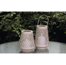 Twee decoratieve windlichten met handvat en gaatjespatroon op een tafel