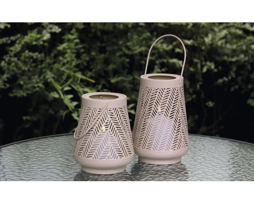 Twee decoratieve windlichten met handvat en gaatjespatroon op een tafel