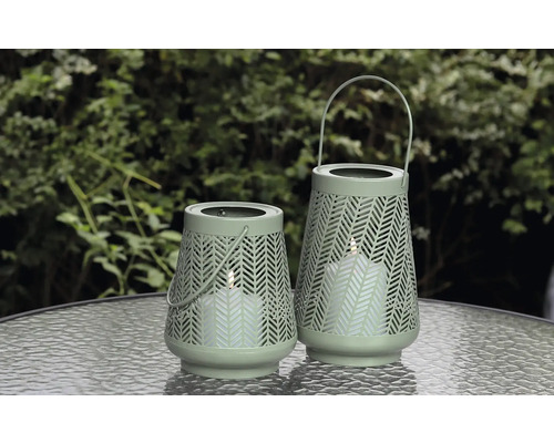 Twee decoratieve windlichten met patroon en handvat op een tafel