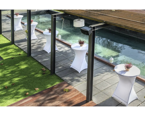 Terras met statafels, planten en een kleine vijver