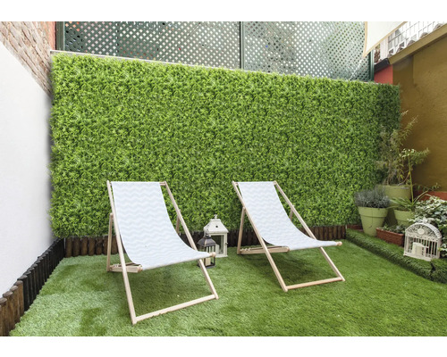 Tuin met kunstgras, privacyscherm en twee ligstoelen