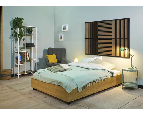 Lichte slaapkamer met bed, rek en fauteuil voor een gezellige sfeer