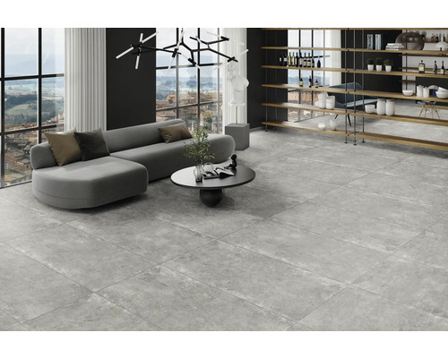 Lichte woonkamer met grijze bank, salontafel en vloertegels