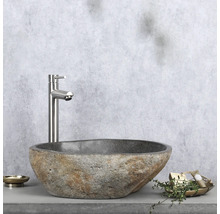 Natuurstenen wastafel met kraan op plank met zeepbakje en decoratie