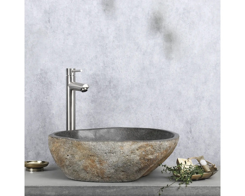 Natuurstenen wastafel met kraan op plank met zeepbakje en decoratie