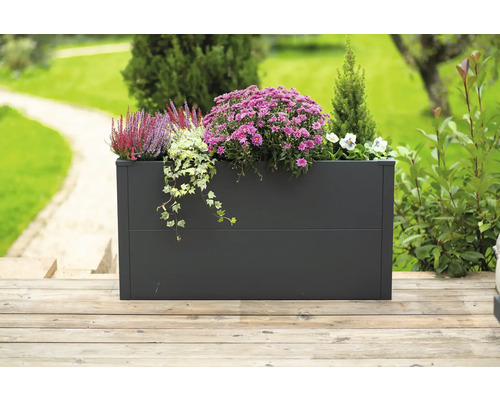 Rechthoekige metalen plantenbak met bloemen en planten op een houten terras