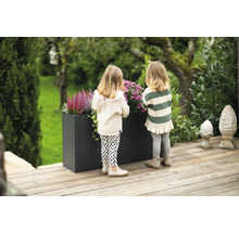 Scène met twee kinderen bij een plantenbak in de tuin