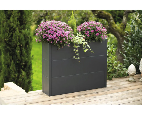 Rechthoekige plantenbak met bloemen en planten in de tuin